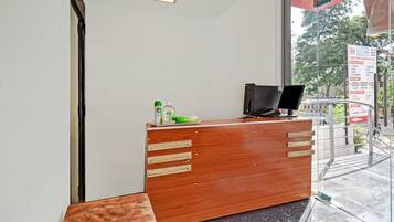 A reception desk with a computer, a telephone, and some office supplies.