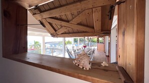 Estructura de techo de madera con vista a un área de estar al aire libre y una piscina.