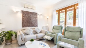 A modern living room with a sofa, a green armchair, and a white coffee table.