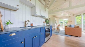 Una cocina moderna con armarios azules, una isla grande y vistas a un balcón con sofá.