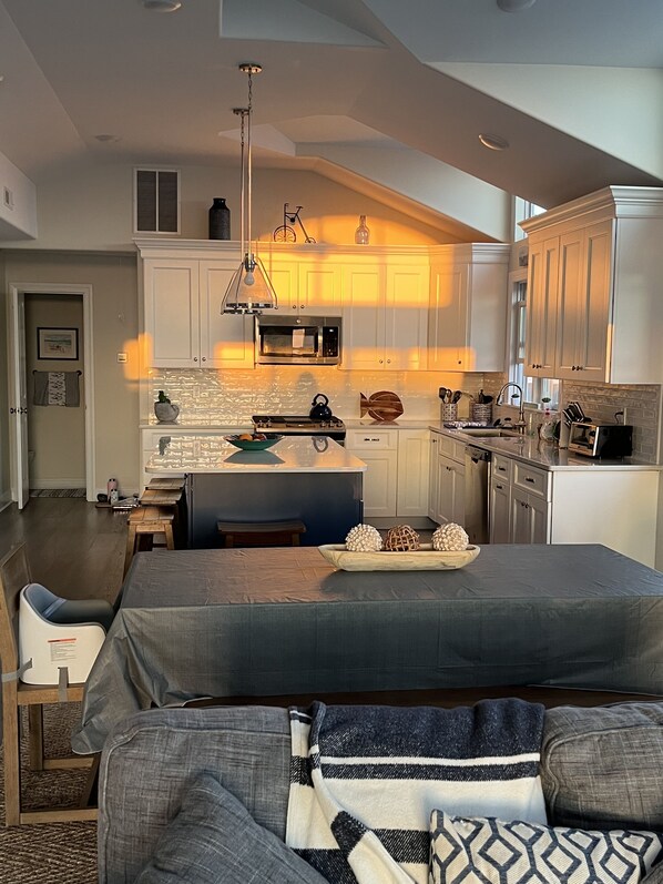 Enjoy cooking in the well-equipped kitchen with a central island, stainless steel appliances, and a dining area.