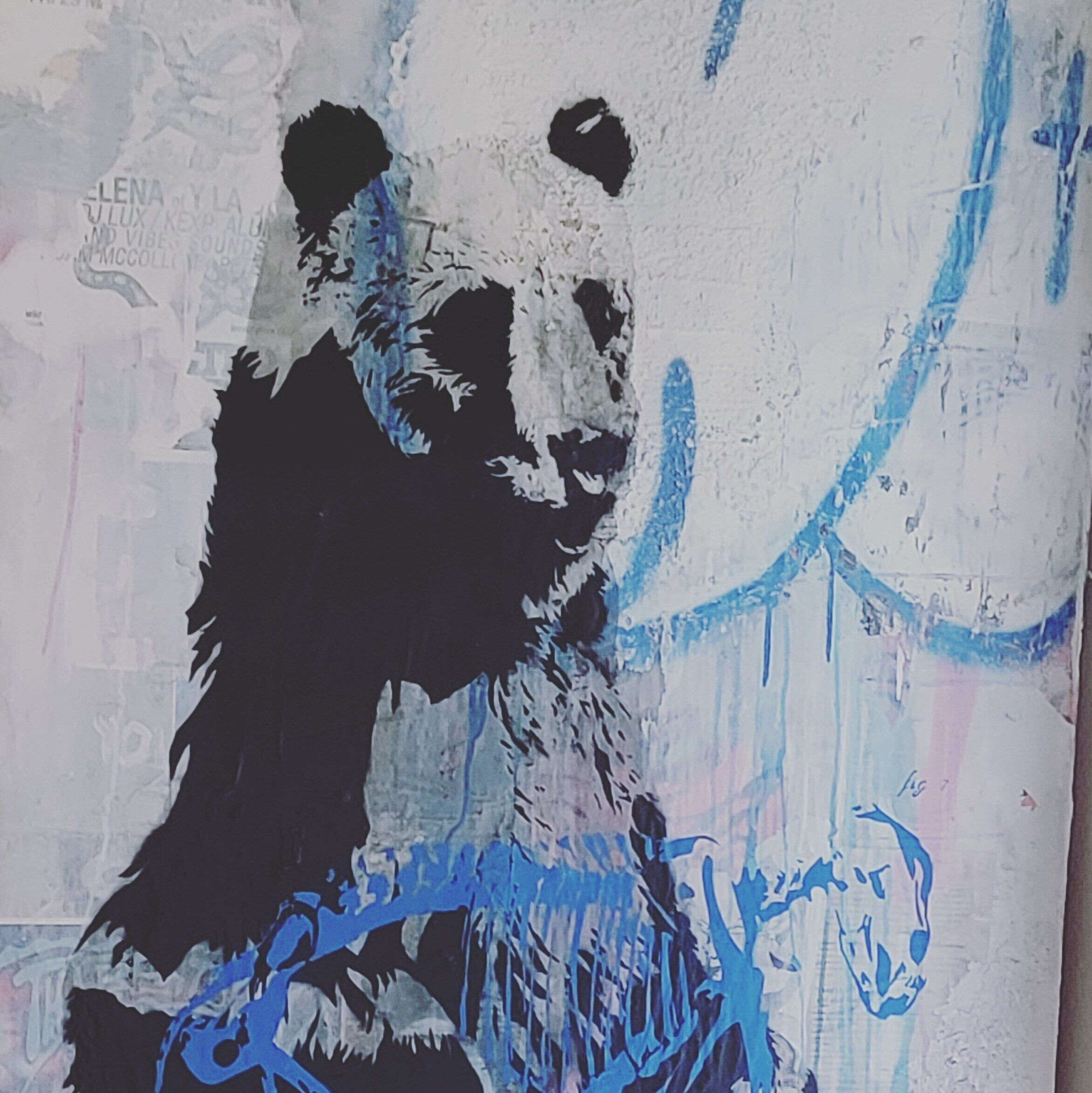 Una pared con una gran ilustración de panda en blanco y negro.