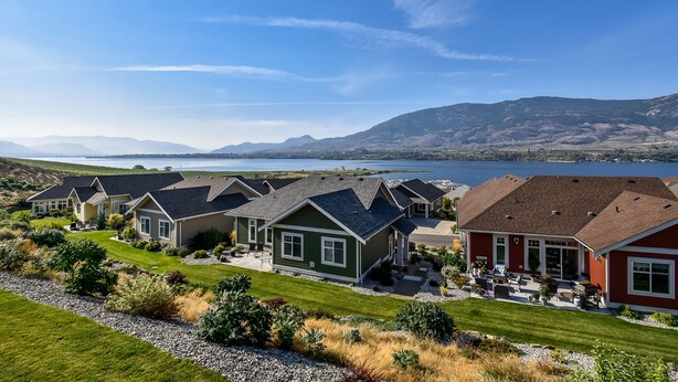 A residential area with houses, a lake, and mountains in the background. - Lake and Mountain Views | Golf cart | Boat slip (Osoyoos)