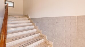 A staircase with wooden steps and a brick wall. - Residence Bellavista - App 4 PP (Torre Lapillo)