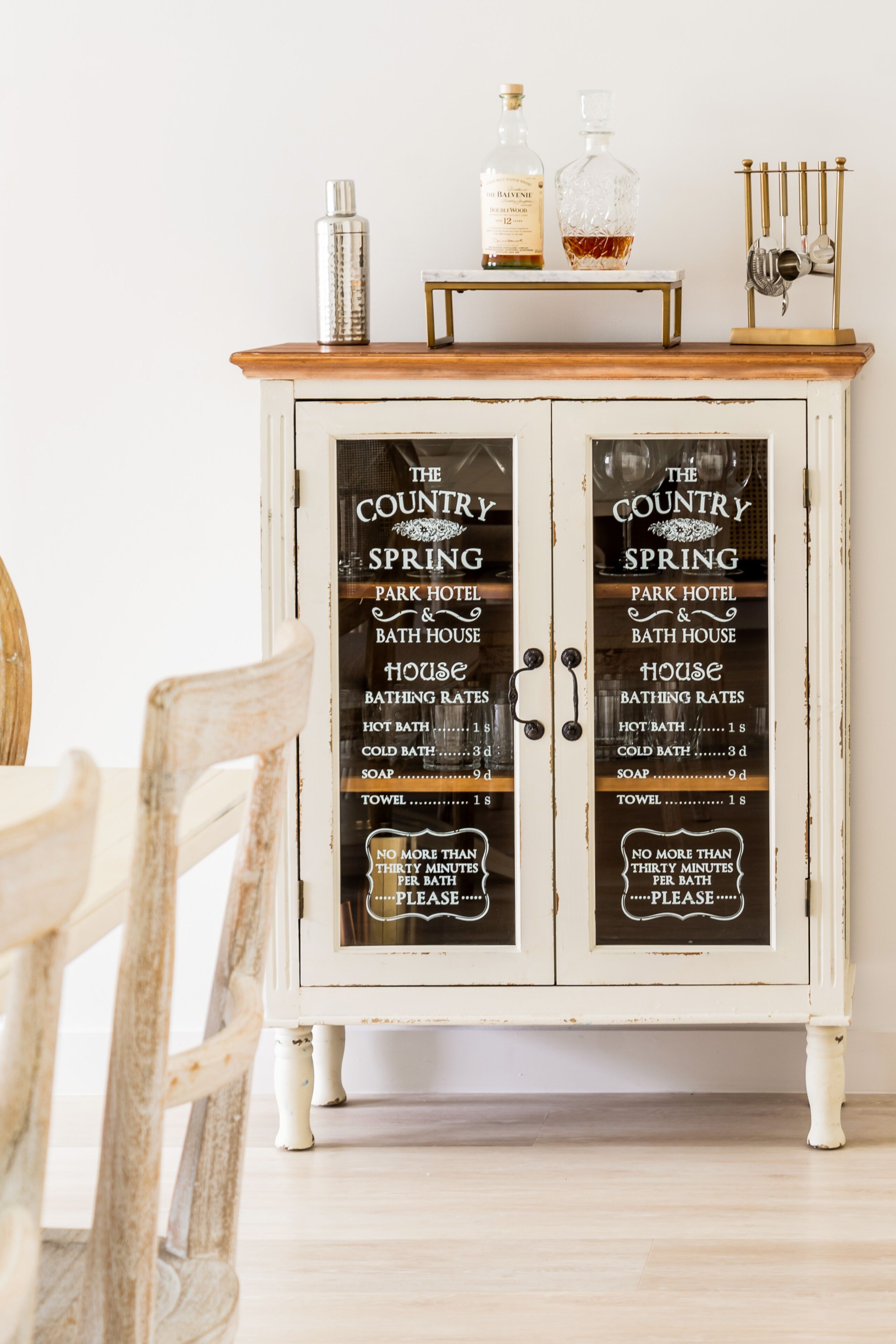 A cabinet with a sign listing The Country Spring Park Hotel & Bath House amenities, including hot bath, cold bath, soap, towel, and a 30-minute bath limit.