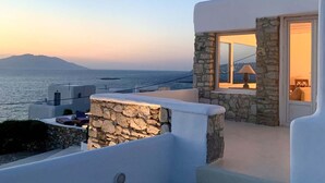 A modern building with stone walls and a balcony overlooking the sea. - Villa Ramona in Mykonos (Mykonos)