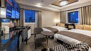 A hotel room with two beds, a desk with a computer, a chair, a small table, and a TV displaying a menu. - APA Hotel Ueno Ekiminami (Tokyo)