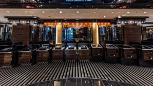 The interior of APA Hotel & Resort with a modern design, featuring a reception area with a chandelier, a check-in counter, and a view of the cityscape through large windows. - APA Hotel & Resort Osaka Umeda Eki Tower (Osaka)