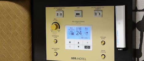 Panel de control con pantalla digital, puerto USB y enchufes.