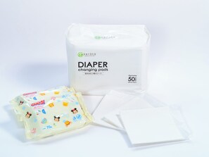 A package of diaper changing pads, a box labeled 'DIAPER changing pads', and a smaller package with cartoon characters. - APA Hotel Asakusabashi Ekimae (Tokyo)