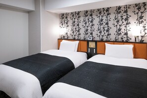 A hotel room with two beds, each with a black and white patterned bedspread, a wooden headboard, and a wall with a floral wallpaper design. - APA Hotel Asakusabashi Ekimae (Tokyo)