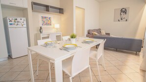 A compact living space with a dining area, kitchenette, and a sofa. - Sweet Lake Apartment (Sirmione)