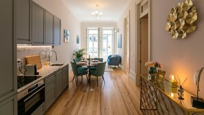 Una cocina moderna con comedor, suelo de madera y vistas a través de puertas abiertas.