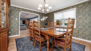 A dining room with a wooden table, chairs, and a chandelier. - Spacious Midcentury home located 1 block from Oaklawn Racing and Gaming (Hot Springs)