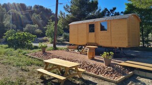 Eine Holzhütte mit einer kleinen Veranda und einem Picknicktisch in einer natürlichen Umgebung.