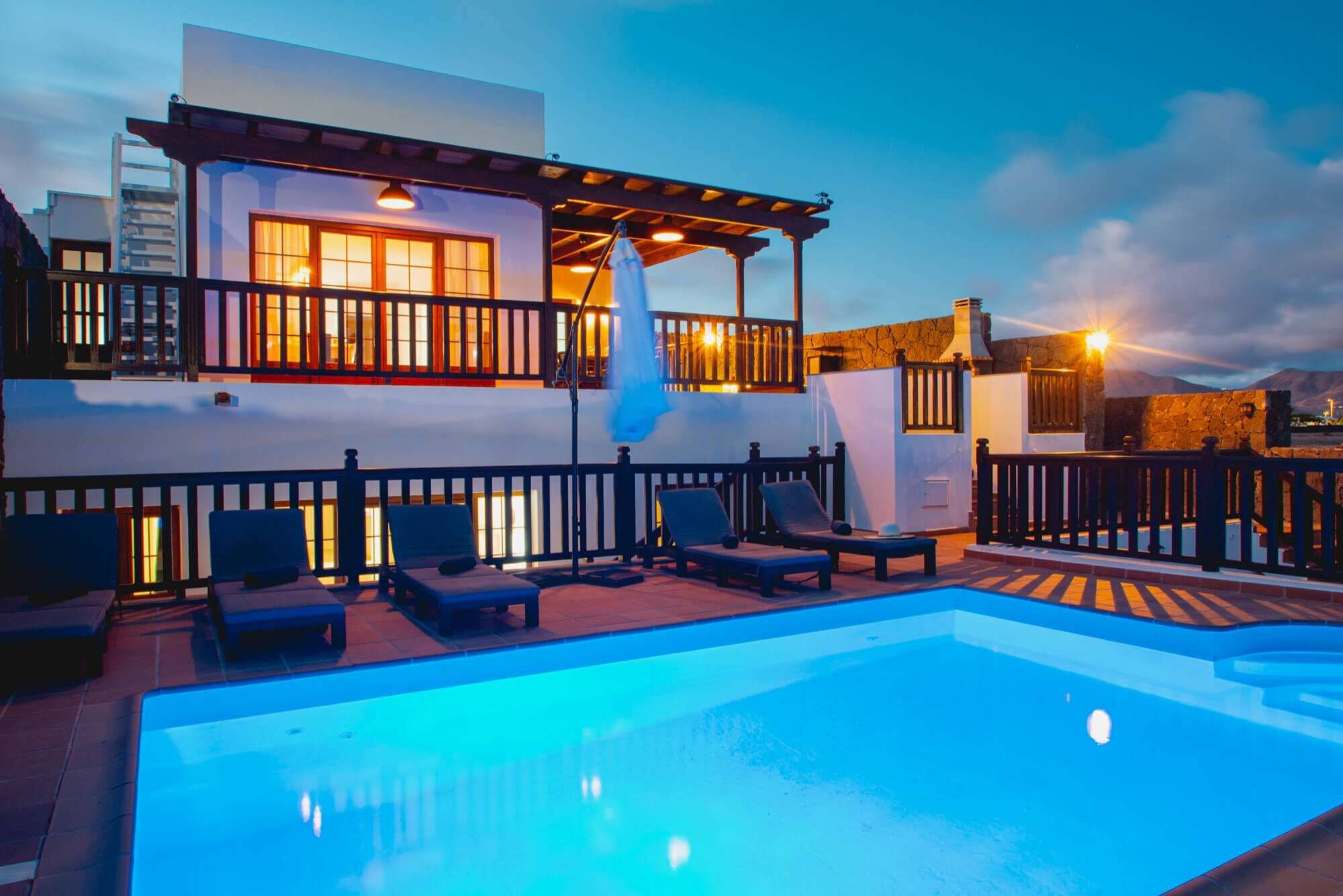 A poolside area with lounge chairs and a pool.