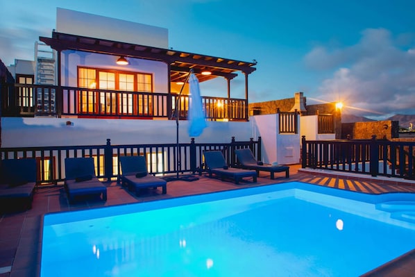 A poolside area with lounge chairs and a pool.