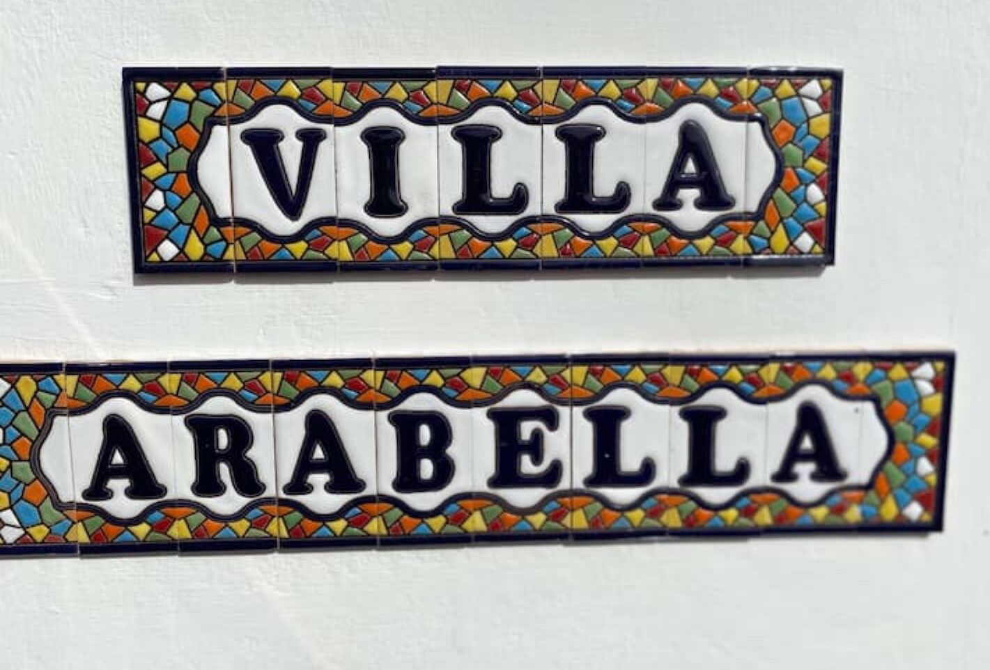 Deux plaques nominatives, «VILLA» et «ARABELLA», ornées de bordures en mosaïque aux couleurs vives.