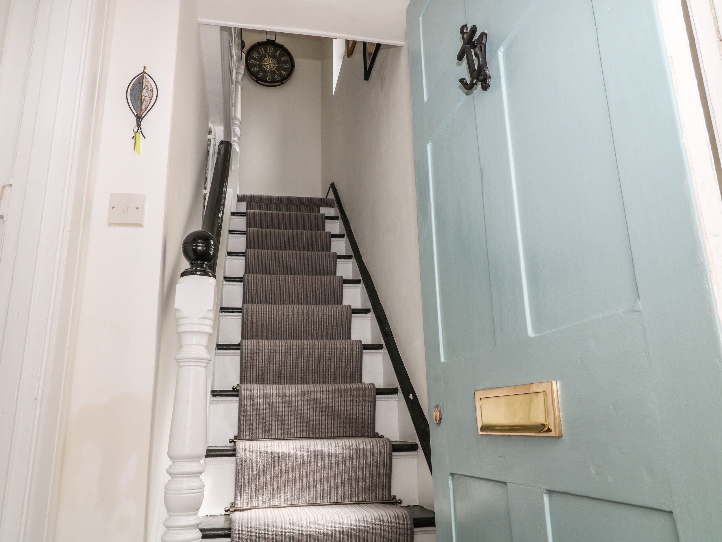 Un escalier surmonté d’une porte bleu clair.