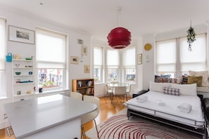 Een moderne hotelkamer met een bed, een eettafel en een keukenhoek.