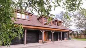 A two-story house with a covered porch, brick exterior, and large windows. - The Barn at Mulberry Lodge (Maidstone)