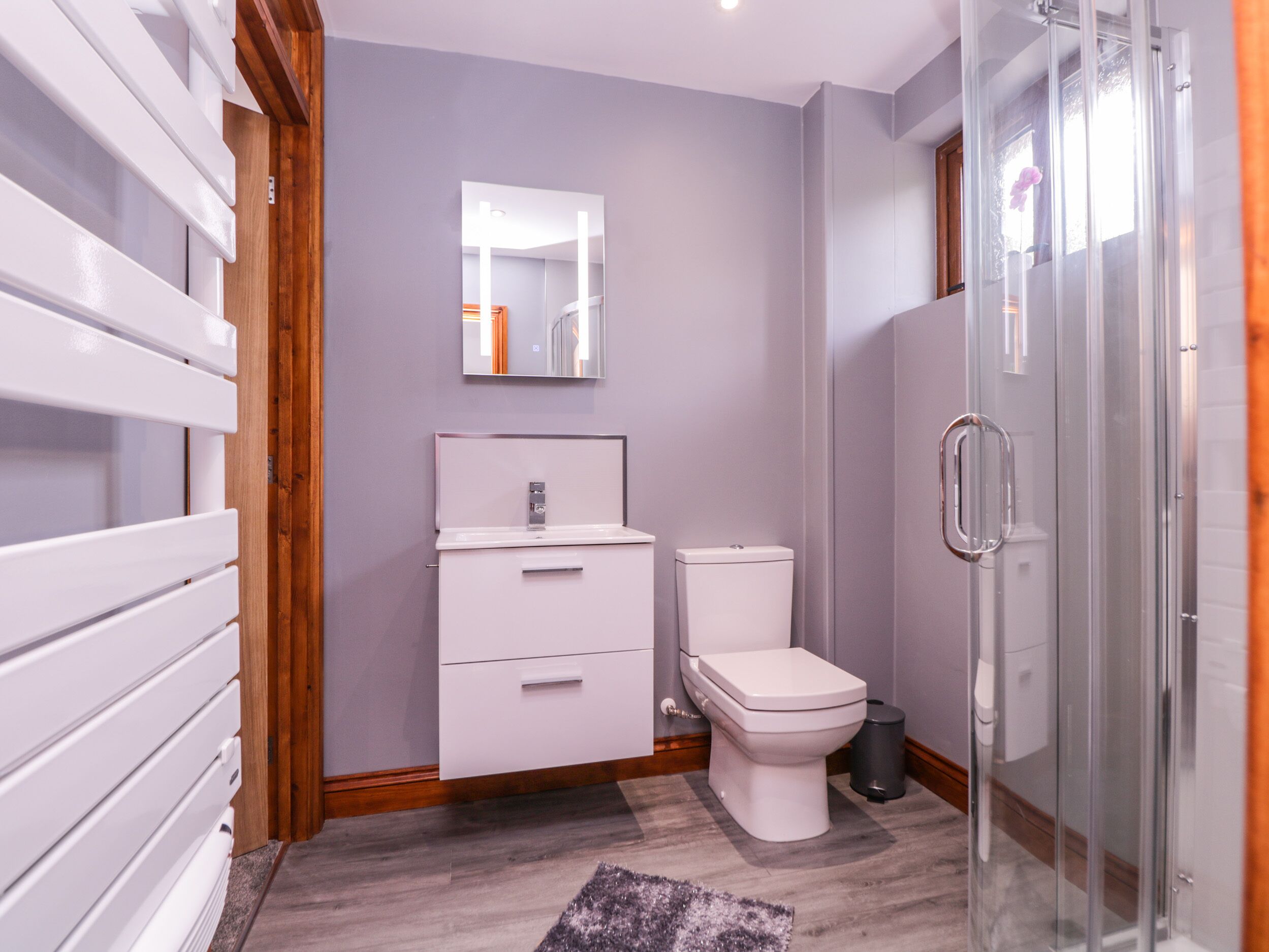 A modern bathroom with a shower, toilet, and sink.