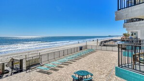 Eine Terrasse am Strand mit Liegestühlen, einem Pool und Blick aufs Meer.