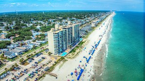 A coastal hotel with multiple floors, a beachside location, and a parking area. - One Ocean Place 1207 - Fabulous 3-bedroom, 3-bath oceanfront condo (Garden City Beach)