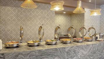 A buffet setup with multiple serving stations, each with a metal bowl and a spoon.