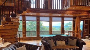 A wooden interior with a pool table, leather sofas, and a spiral staircase. - Epic views! Hot tub under the stars, close to lake (Broken Bow)