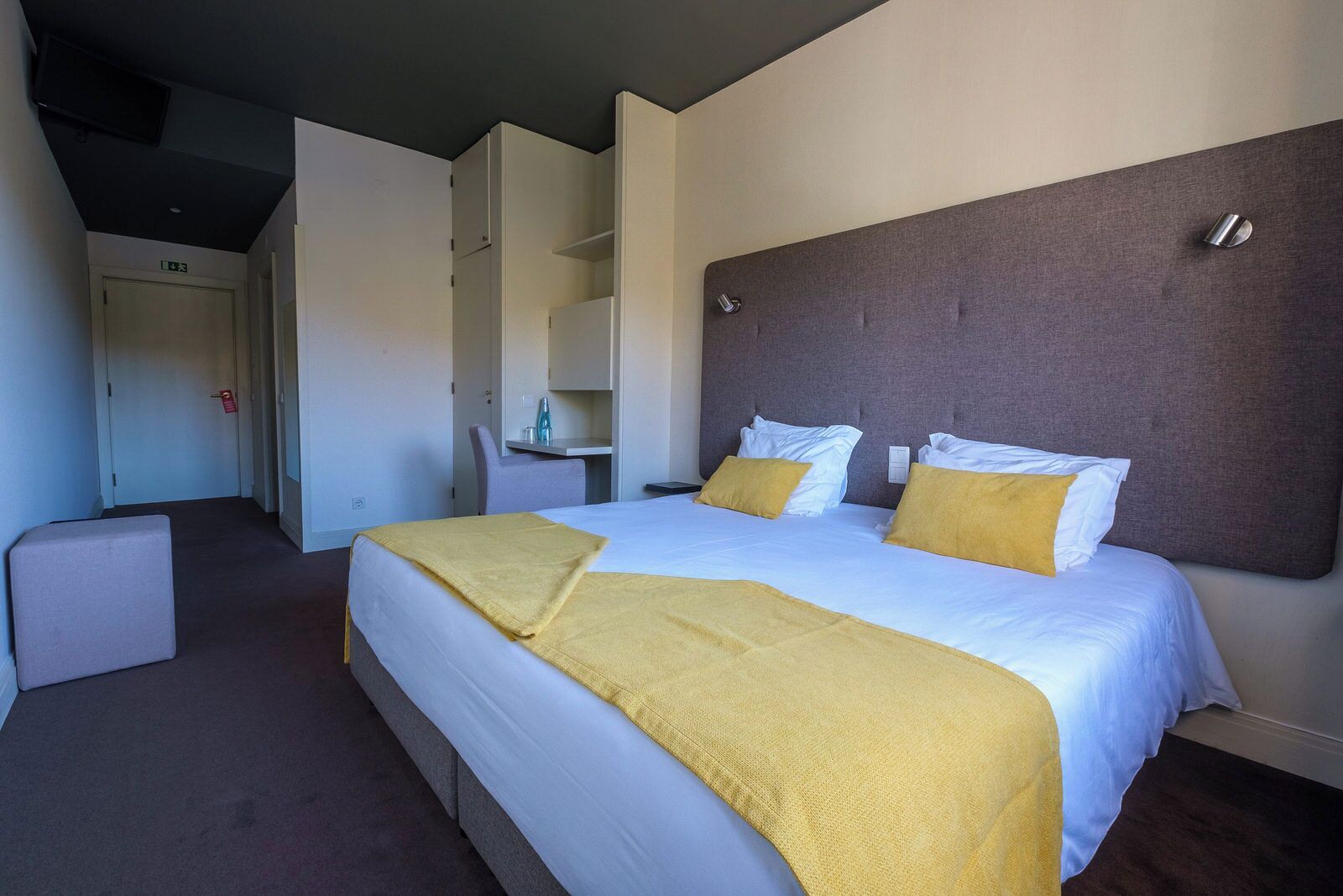 Una habitación de hotel con una cama grande, un escritorio y una silla.