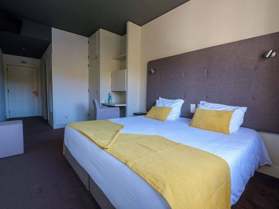 Una habitación de hotel con una cama grande, un escritorio y una silla.