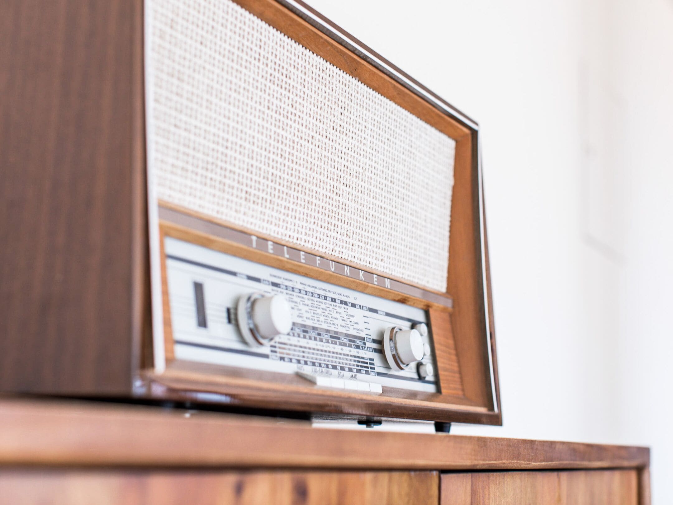 Une radio en bois, dotée d’une grille sur le dessus et de boutons de réglage.
