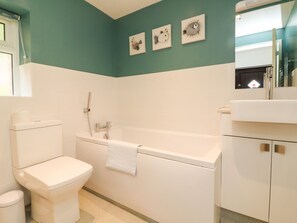 A bathroom with a toilet, bathtub, and a sink. - Honeysuckle Cottage (Barnstaple)