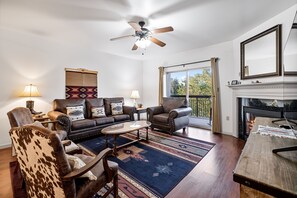 A living room with leather furniture, a patterned rug, and a fireplace.
