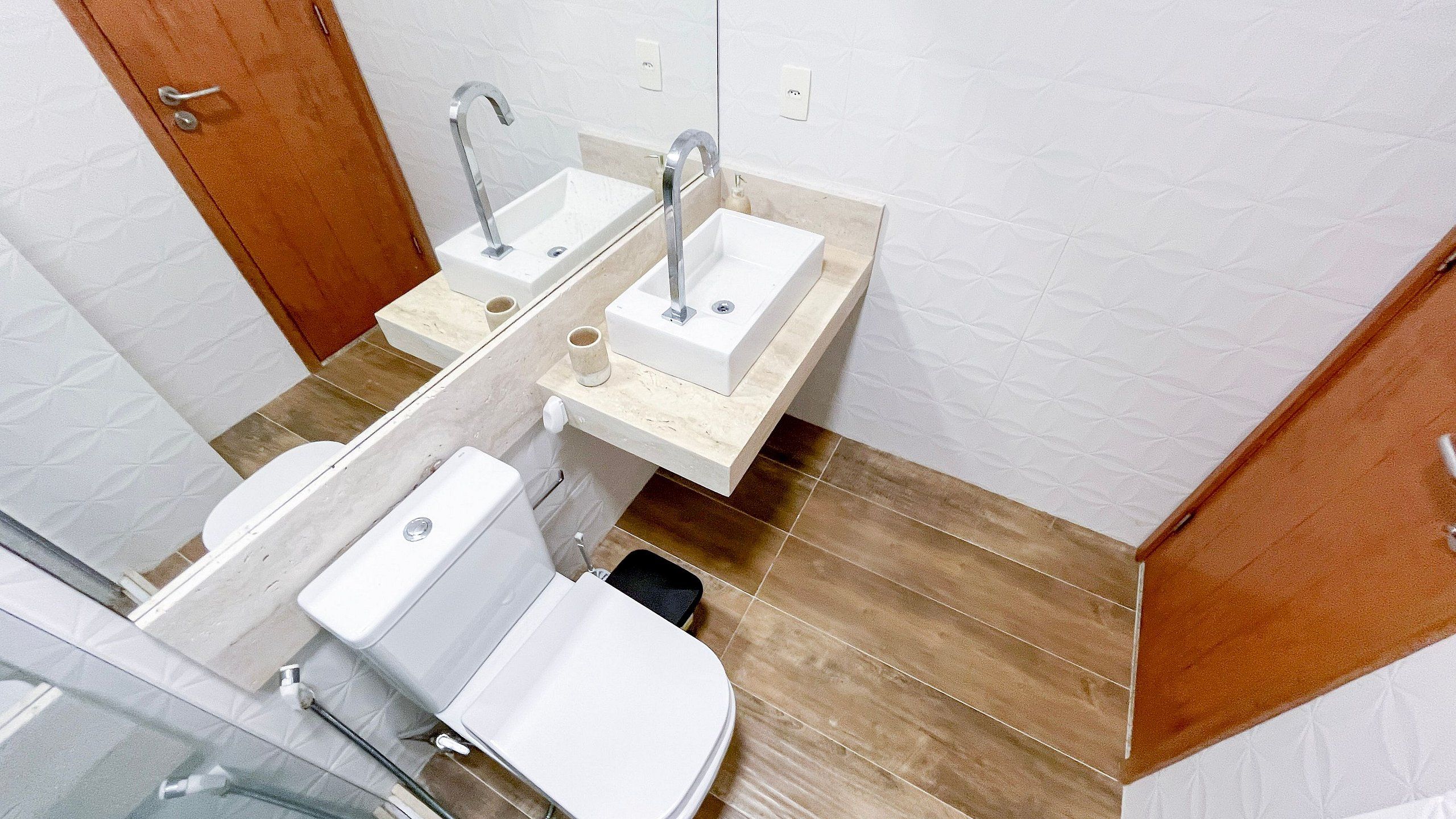 A bathroom with two sinks, a toilet, and a shower.