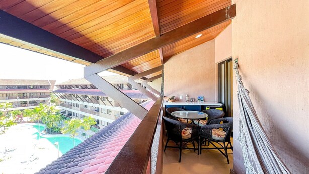 Un balcón con vista a una piscina y edificios circundantes.