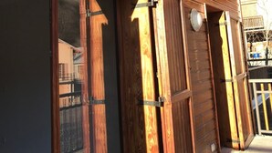 A wooden exterior with a sliding glass door and a small balcony. - Guillestre T2 with terrace, close to shuttles to Queyras resorts (Guillestre)