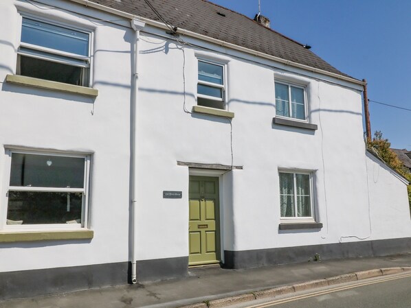 A white two-story building with a green door, multiple windows, and a visible sign reading "Old Town House." - Old Town House (Dawlish)