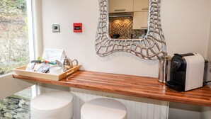Un bagno con un mobile vanitario in legno, uno specchio e una macchina per il caffè.