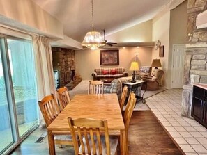 Cozy living room with a fireplace, comfortable seating, and dining area, perfect for relaxation and dining.