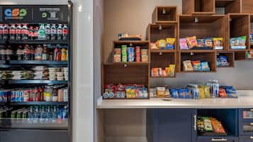 A vending machine stocked with various beverages and snacks, with shelves above and below for additional items.