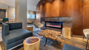 Un área de descanso moderna con un sofá, una mesa redonda de madera y una chimenea.