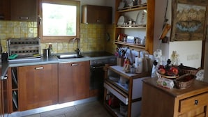 Una cocina con armarios de madera, un lavamanos, una ventana y un reloj en la pared.