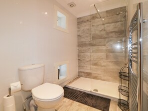 A modern bathroom with a toilet, a shower, and a glass-enclosed shower area. - Fonthill (Torquay)