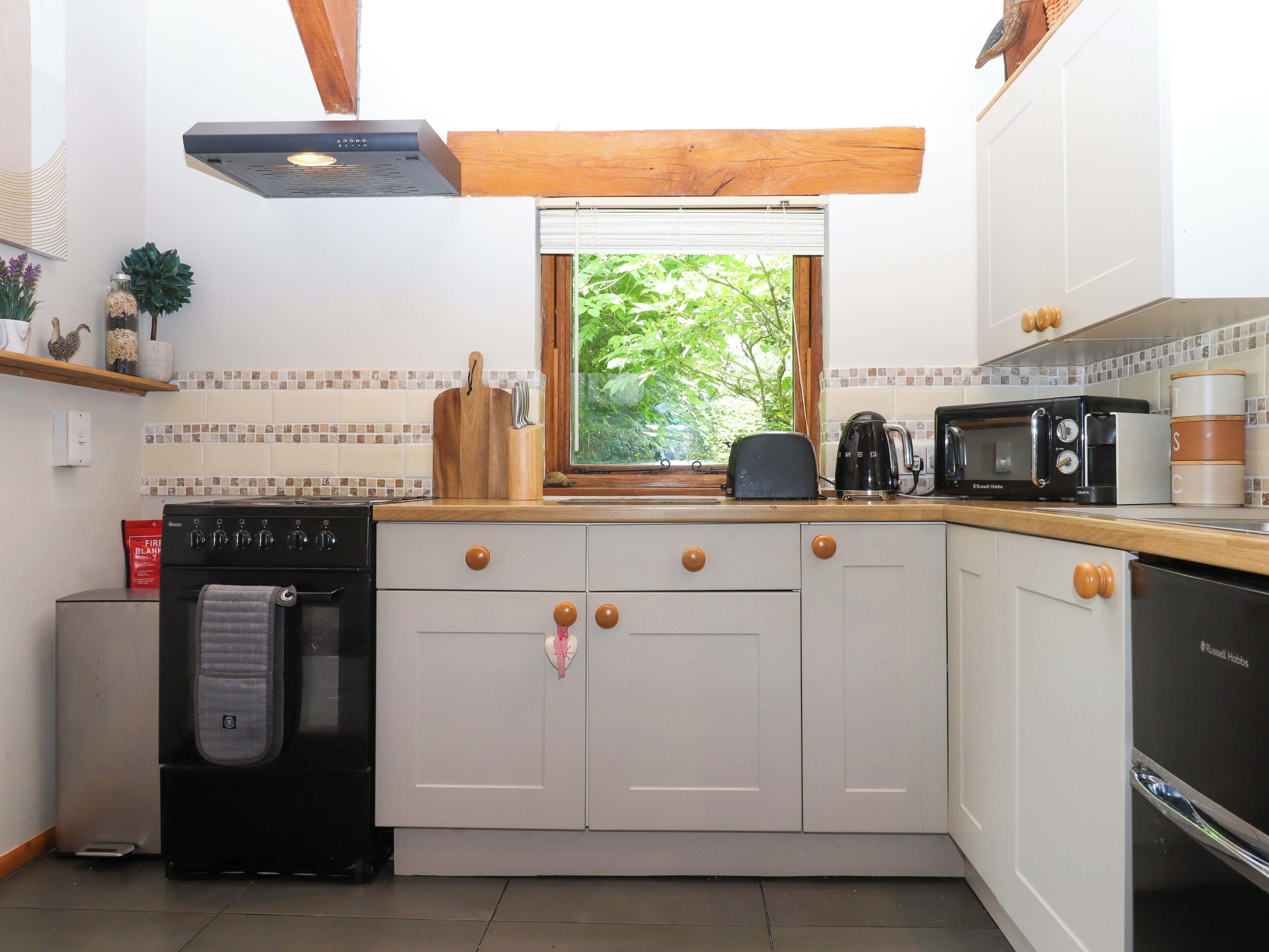 Cocina compacta con horno integrado, tostadora, hervidor y microondas.