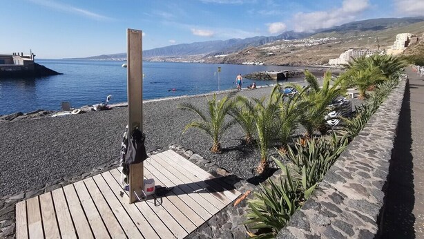 A beach with a wooden deck, palm plants, and a rocky shoreline. - Home2Book Comfy Beachfront Radazul (Radazul)
