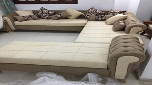 A beige sectional sofa with multiple cushions, a matching ottoman, and plastic covering on the floor. - BIG VILLA WITH A PARKING  (Site archéologique de Carthage)
