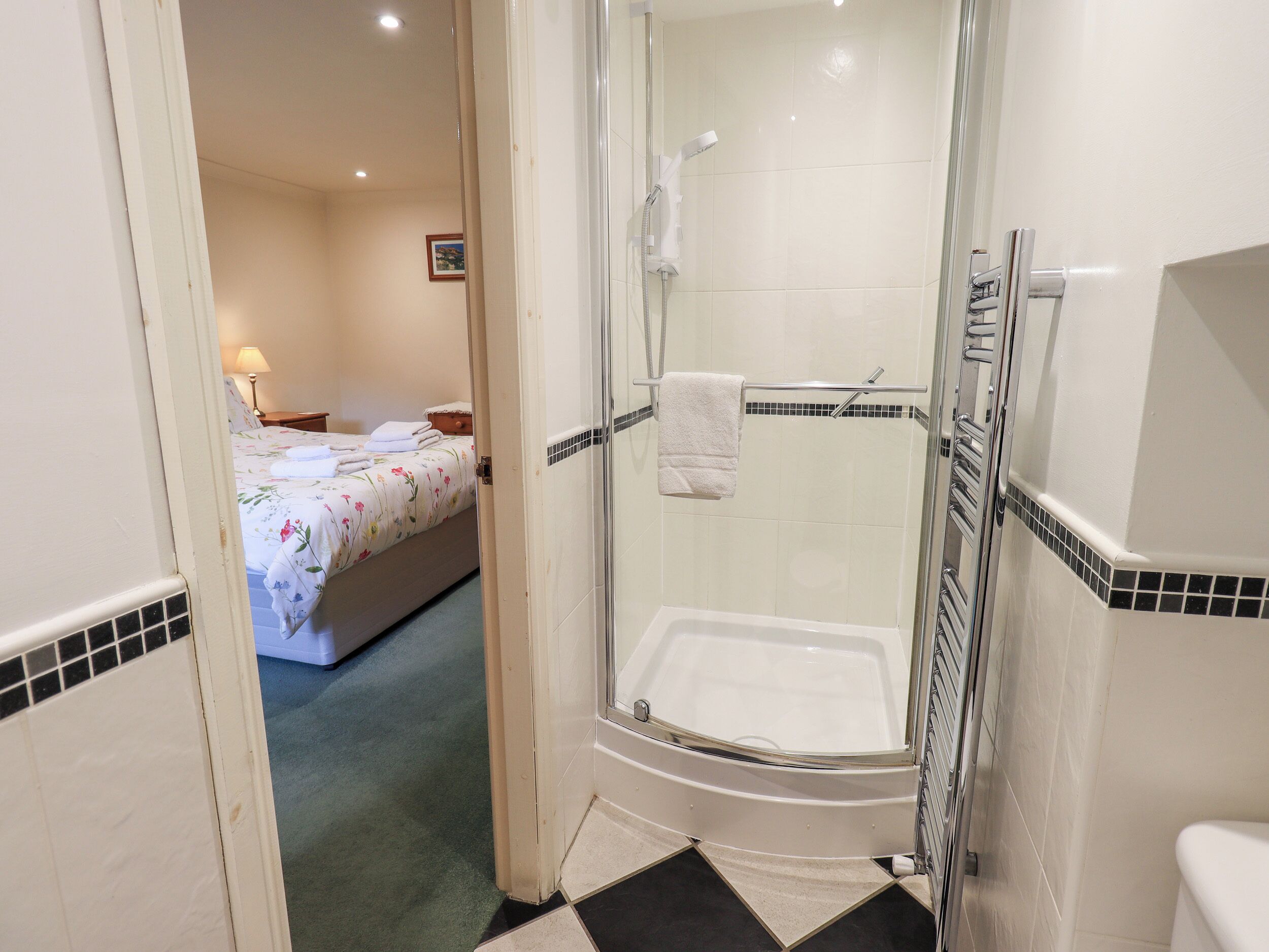 Une salle de bain avec une douche à parois de verre, une baignoire blanche et des toilettes.