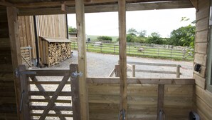 A wooden barn entrance with a gate, a stable door, and a metal latch. - Langdale Lodge (Okehampton)